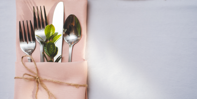 Pink napkin folded with cutlery tucked inside