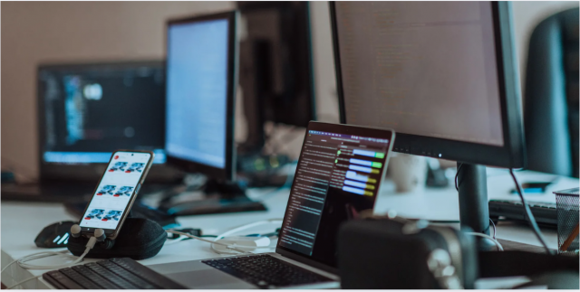  computer screens running programming code in empty software developing agency