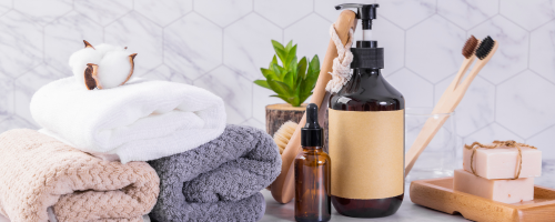 Set of amenities in the toilet, including soap, shampoo, conditioner, and body lotion arranged on a clean and well-lit counter.